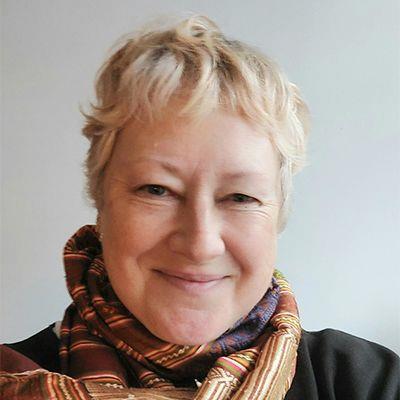 Porträt von Andrea Mbarushimana mit kurzen, hellblonden Haaren und einem bunt gemusterten Schal vor hellem Hintergrund